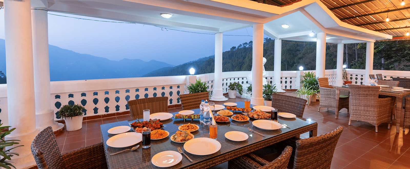 A scenic dining area at DLS Tehri Club Resort with a breathtaking view of the mountains.